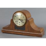 A 1930's 8 day chiming mantel clock with silvered dial and Arabic numerals contained in an oak