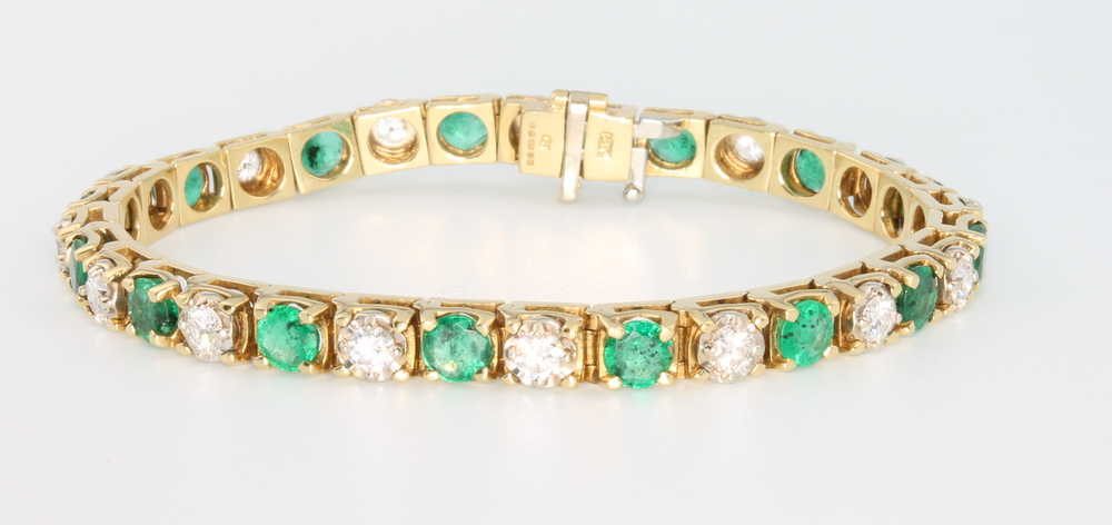 An 18ct yellow gold diamond and emerald bracelet, the brilliant cut diamonds approx. 5ct, the