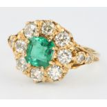 An 18ct yellow gold emerald and diamond cluster ring, the centre stone approx. 1.20ct, surrounded by