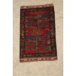 A blue and red ground Persian pictorial rug of trees and buildings 51" x 32"