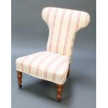 A Victorian nursing chair upholstered in striped material and raised on turned supports