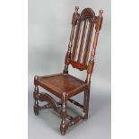 A 17th/18th Century oak high back hall chair with solid seat and carved apron raised on turned and