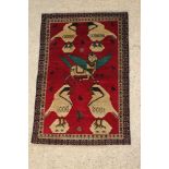 A red ground pictorial Persian rug with birds, mythical winged beast dated 2006 54" x 36"