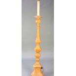 A pine Rococo style standard lamp in the form of an altar candlestick 63", raised on a triform