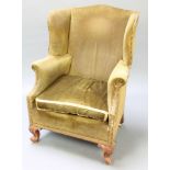 A 19th Century Continental winged armchair upholstered in green material, raised on carved