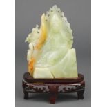 A Chinese carved jadeite figure of a deity and dragon on a hardwood stand 5 1/2"