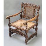 A Carolean style carved oak armchair with pierced and carved back and woven cane seat (f)