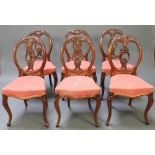 A set of 6 Victorian carved walnut balloon back dining chairs with pierced vase shaped slat backs,