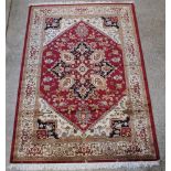 A red and cream ground Heriz rug with diamond shaped medallion to the centre 110" x 79"