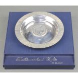 A silver dish with bark finish rim inset a coin Sheffield 1973, 134 grams, boxed