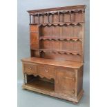 An oak Arts & Crafts dresser, the upper section with moulded and pierced cornice fitted 3 shelves