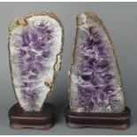 2 shaped and polished sections of amethyst 13" x 6" and 12" x 6", raised on wooden bases