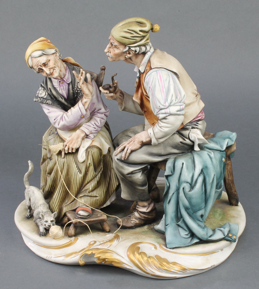 A Capodimonte group of an elderly lady and gentleman with a cat at their feet 11"