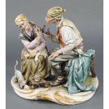 A Capodimonte group of an elderly lady and gentleman with a cat at their feet 11"