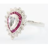 An 18ct white gold pear shaped diamond and ruby ring, the centre diamond approx. 0.52ct surrounded