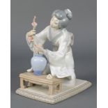 A Lladro figure of a Japanese lady kneeling before a table 8/28 7 1/2" The branch has been