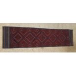 A red and blue ground Meshwani runner with 5 diamonds to the centre 98" x 24"