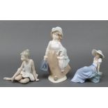 A Spanish porcelain figure of a lady 10", a Nao figure of a girl sitting on a rock 6" and another of