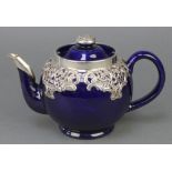 An Edwardian silver mounted Doulton teapot with repousse mounts, London 1906