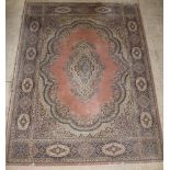A Persian style machine made pink ground and floral patterned carpet having a central medallion 144"
