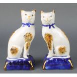 A pair of Staffordshire style figures of cats sitting on cushions 8"