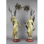 A pair of Art Nouveau bronze lanterns in the form of standing girls having reeds, raised on polished