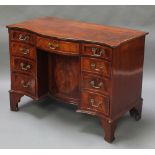 A Georgian mahogany dressing table of serpentine outline, the crossbanded top with ebonised