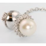 A white gold pearl and diamond tie pin with steel back