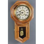 A striking wall clock with painted dial and Roman numerals contained in a walnut finished case