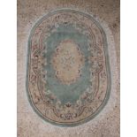 An oval turquoise and floral patterned Chinese rug 75" x 49"