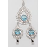 A cubic zirconia pear shaped pendant and earrings set with pale blue stones