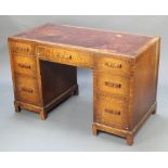 An Art Deco oak kneehole desk with brown leather writing surface fitted 1 long drawer flanked by 6