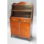 A Georgian style mahogany waterfall bookcase, fitted 2 drawers above a double cupboard, raised on