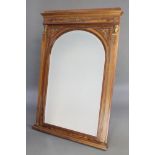 A French Empire style arched bevelled plate mirror contained in a walnut and gilt mounted frame with