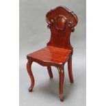 A Victorian carved mahogany hall chair with shaped solid seat and back, raised on cabriole supports