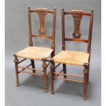 A pair of Art Nouveau carved oak splat back bedroom chairs with woven rush seats, raised on turned