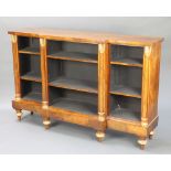 A Regency mahogany breakfront bookcase fitted adjustable shelves and column decoration, raised on