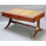 A Regency style rectangular mahogany library table with green inset writing surface fitted 3 drawers