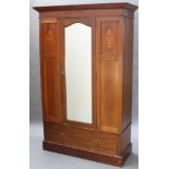 An Edwardian inlaid mahogany wardrobe with moulded cornice enclosed by arched bevelled plate