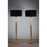 A PAIR OF BRASS STANDARD LAMPS, on column supports and circular bases, each 177cm high