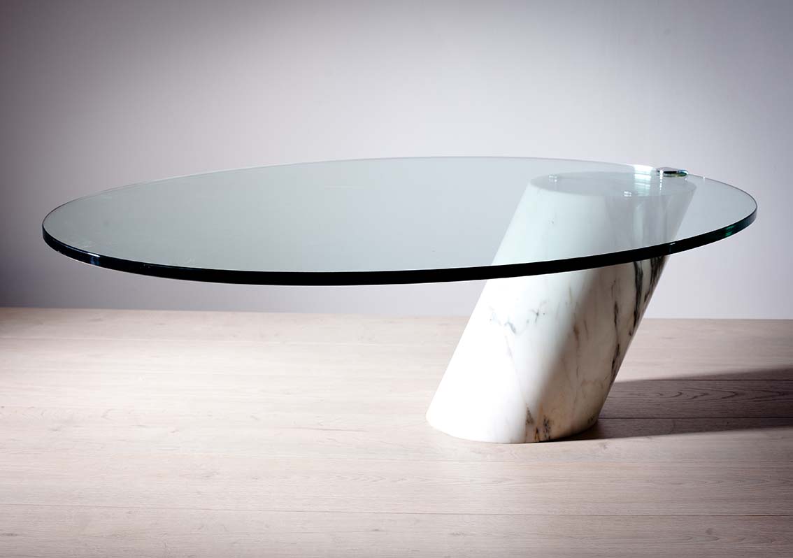 AN OVAL ELIPTICAL COFFEE TABLE, BY CINI BOERI, the thick glass top on a cantilever marble plinth