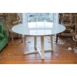 A CIRCULAR DINING TABLE, ITALIAN BY I.M.S, the white glass circular top on a crossover base, 152cm