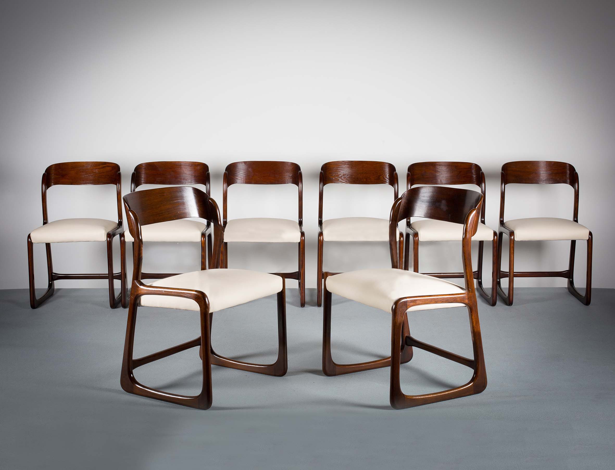 A SET OF TEN DINING CHAIRS, FRENCH 1970s, with rounded tablet backs, on shaped supports. (10)