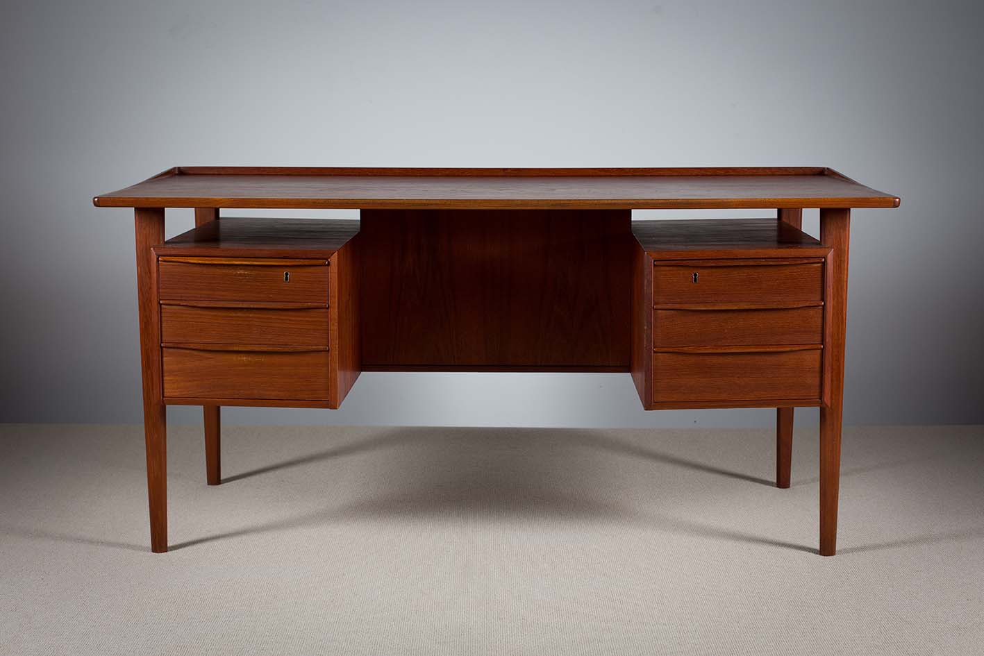 A TEAK KNEEHOLE DESK, DANISH, BY PETER LOVIG NIELSEN FOR DANSK DESIGNS, DENMARK, with a pair of