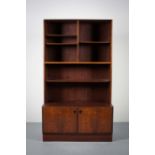 A SINGLE ROSEWOOD BOOKCASE EN SUITE, DANISH, with two cupboard doors