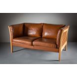 A TAN LEATHER TWO SEATER SOFA, DANISH, BY STOUBY, on square legs