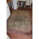 AN ORIENTAL RUG ON A RED GROUND, (worn),