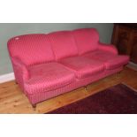 AN UPHOLSTERED THREE SEATER SOFA, on tur