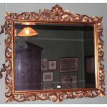 A GILTWOOD WALL MIRROR, with central she