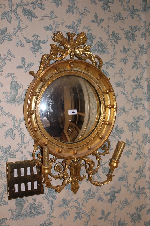 A REGENCY STYLE CONVEX MIRROR, the top s